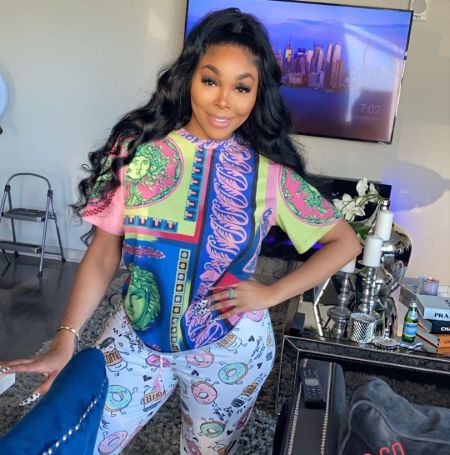 Sierra Gates in a white pant and a colorful top poses at her house.